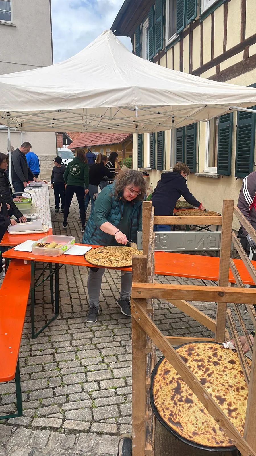 Gäste am Backhausfest vor dem Fachwerkhaus in der Dorfmitte