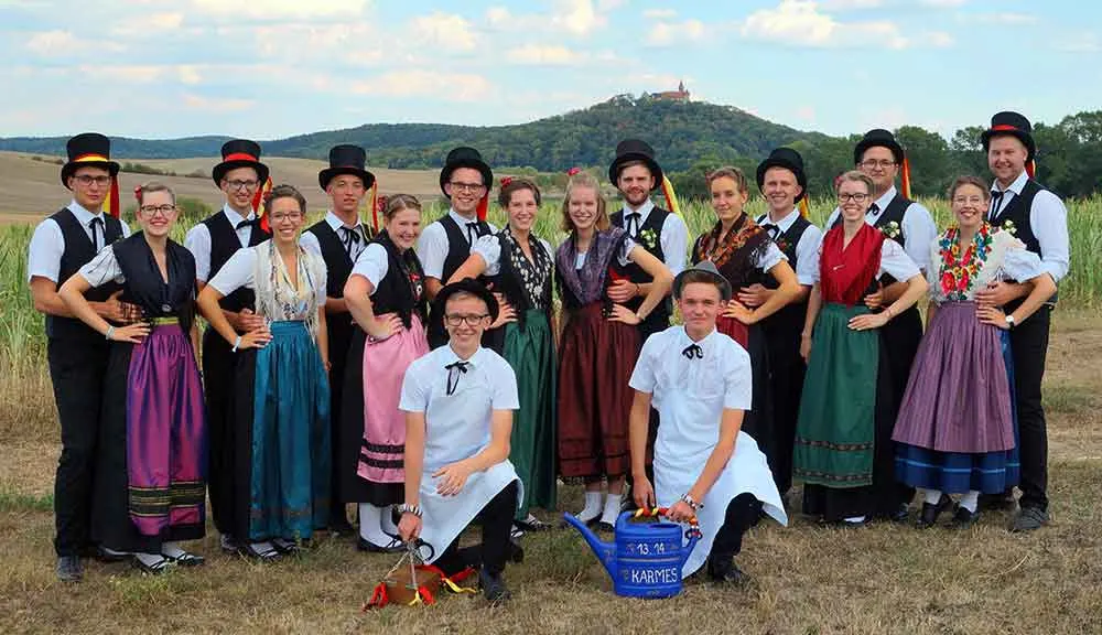 Kirmesgesellschaft in Tracht vor der Veste Heldburg